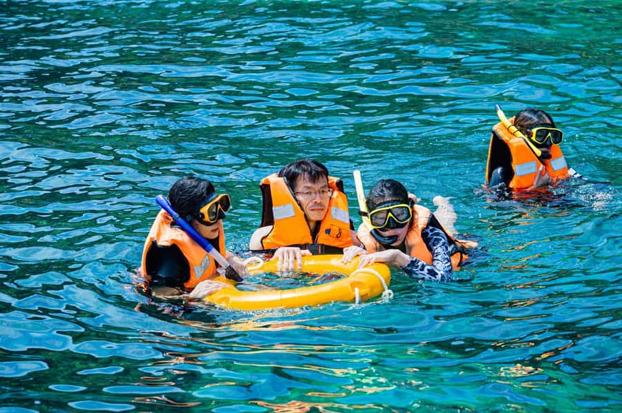 From Phuket: Coral Island Kahung Beach Speedboat Trip - Kahung Beach, beach chairs, and emerald water